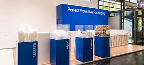 Ein Messestand von Storopack mit vier blauen Vitrinen