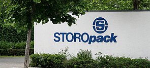 Eine weiße Mauer mit blauem Storopack Logo